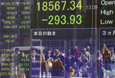 People are reflected on an electronic stock indicator of a securities firm in Tokyo - Asian stocks were mostly lower Thursday, as the region nervously watched for market-moving news from the first meeting between the U.S. and Chinese leaders