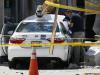 An official photographs the scene where police say a taxi driver struck a group of pedestrians, injuring several, Monday, July 3, 2017, in Boston. A police official said the crash is believed to be a case of "operator error" in which the driver stepped on the gas pedal instead of the brake. (AP Photo/Michael Dwyer)