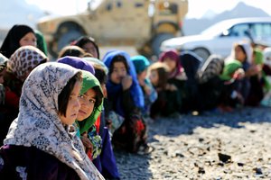 File - A young Afghan girl stares into the camera lens at a local returnee and refugee village in Farah province, Afghanistan, Feb. 9, 2013.