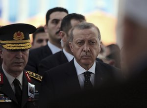 Turkey's President Recep Tayyip Erdogan, right, listens as he attends funeral prayers for army general Aydogan Aydin, one of 13 army officers who were killed in a helicopter crash in Sirnak, late Wednesday, in Ankara,