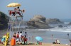 Lifeguards sit in an coastguard watchtower as people enjoy the sunny weather on a beach in Biarritz, southwestern France.