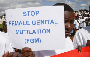 File - A Masai girl holds a protest sign during the anti-Female Genital Mutilation (FGM) run in Kilgoris, Kenya, April 21, 2007.