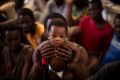 A man from Nigeria holds his 6 months old baby, on their way to Italy after being rescued along with more than 600 ...