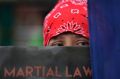 An activist holds a placard denouncing martial law during a rally, Wednesday, July 5, 2017, in Manila, Philippines. The ...