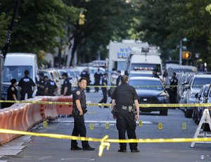 Numbers mark a crime scene near the site where a police officer was fatally shot in the Bronx section of New York, Wednesday, July 5, 2017. Police said other officers shot and killed the suspect after he drew a revolver on them. (AP Photo/Seth Wenig)