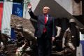 President Donald Trump waves as he arrives to deliver a speech at Krasinski Square.