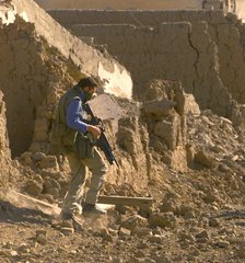 A member of the British SAS special forces inspects a deserted al-Qaida training camp on the southern outskirts of Kandahar airport Tuesday Dec. 11, 2001.