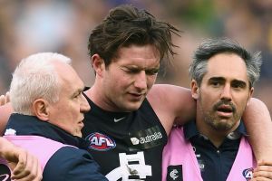 Jed Lamb is helped from the ground by trainers after being elbowed by Bachar Houli. 