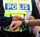 A police officer attaching a bracelet with the text "tafsainte", meaning don't grope, to a visitor's wrist at the ...