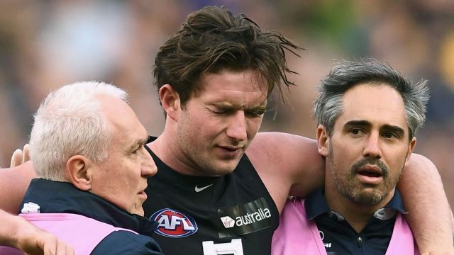 Jed Lamb is helped from the ground by trainers after being elbowed by Bachar Houli. 