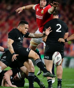 New Zealand halfback Aaron Smith, center, kicks the ball during the third and final rugby test between the British and ...