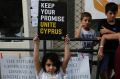 A girl holds up a board  during a peace protest in the divided capital of Nicosia, Cyprus, on  July 6. 