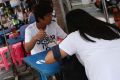 Lunch time: People eat noodles at a street food stall on Thonglor road, Bangkok, Thailand. Officials see street food as ...