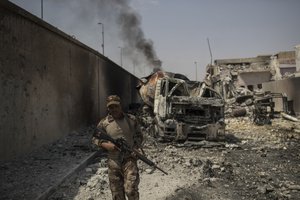 An Iraqi army soldier walks on a damaged street as Iraqi forces continue their advance against Islamic State militants in the Old City of Mosul, Iraq, Saturday, July 8, 2017.