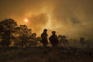 CalFire firefighter Jake Hainey, left, and engineer Anna Mathiasen watch as the Wall fire burns near Oroville, Calif., on Saturday, July 8, 2017. According to CalFire, the blaze has burned 2,700 acres and destroyed 10 homes.