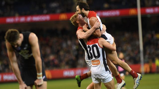 In the mix: Melbourne players after their hard-fought comeback win over Carlton.