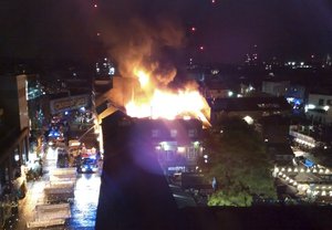 Flames and smoke rise from a fire affecting a small area of Camden Market in London early Monday July 10, 2017.