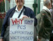 Former PCS rep with a placard reading 'why won't PCS support victimised reps?'