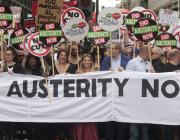 Marchers in London standing behind a banner saying 'End Austerity Now'