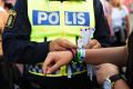 A police officer attaching a bracelet with the text "tafsainte", meaning don't grope, to a visitor's wrist at the ...