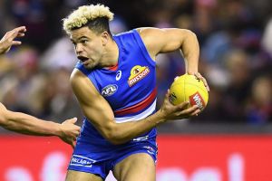 Jason Johannisen of the Bulldogs is chased by Nathan Hrovat of the Kangaroos during the round 14 AFL match between the ...