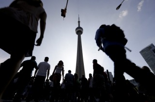 People make their way towards the CN Tower and Rogers Centre for the opening ceremony in the Pan Am Games in Toronto, ...