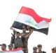 Iraq's prime minister Haider al-Abadi raises the national flag as he addresses forces  on the edge of Mosul's Old City.