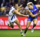 Jason Johannisen of the Bulldogs is chased by Nathan Hrovat of the Kangaroos during the round 14 AFL match between the ...