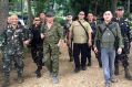 President Rodrigo Duterte, centre left, wearing a bullcap and an assault rifle slung on his shoulder, walks with  ...