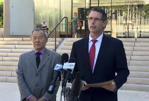 Paul Delacourt speaks at a news conference as Acting United States Attorney Elliot Enoki listens outside federal court in Honolulu, July 10, 2017.