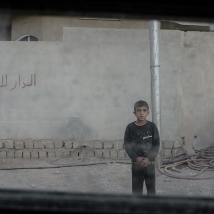 A young boy stares at the photographer through the window of an Iraqi army Humvee in the Karkukli neighborhood of Mosul, Iraq on Nov. 17, 2016.