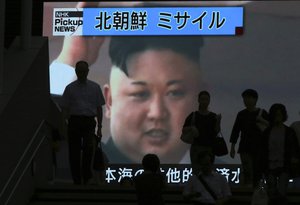 People walk past a TV news showing an image of North Korean leader Kim Jong Un while reporting North Korea's missile test which landed in the waters of Japan's economic zone (EEZ) in Tokyo Tuesday, July 4, 2017.