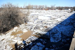 File - Large sheets of ice cause a jam near the base of a bridge across the Bighorn River in Worland, Wyo., Feb. 12, 2017. Wyoming National Guardsmen assisted with response efforts to mitigate ice-jam induced flooding in the area.