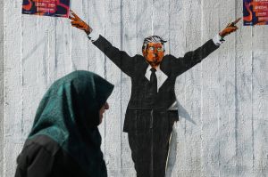 BERLIN, GERMANY - JUNE 27: A Muslim woman walks past a street artist's rendition of U.S. President Donald Trump on June ...