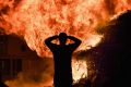 Loyalist are silhouetted as they gather in front of the bonfire on the Sandy Row area on July 12, 2017 in Belfast, ...