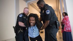 A demonstrator is taken into custody by U.S. Capitol Police as activists protest against the Republican health care bill ...