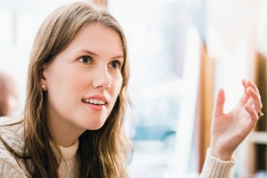 Shocked young woman gesturing while looking away at restaurant