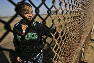 Aleida Gutierrez stands on the US side the U.S.-Mexico border fence as she waits for relatives that still live in Mexico at the Playas de Tijuana area of Tijuana, Mexico, Sunday, Jan. 20, 2008.