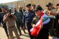 Iraq's Prime Minister Haider al-Abadi holds a national flag upon his arrival in Mosul on Sunday to mark the defeat of ...