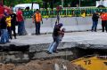 Workers are lowered by a crane as they work to rescue a vehicle that drove into a sinkhole on a highway in Cuernavaca, ...