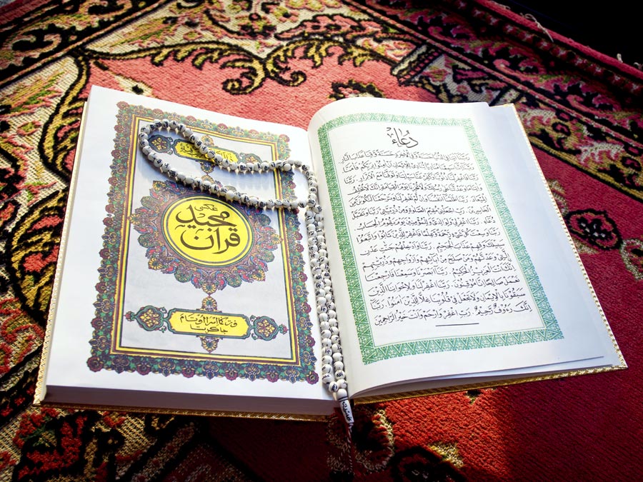 Prayer beads on Quran or Koran written in Arabic Islam’s sacred and liturgical language. text, words, Ramadan