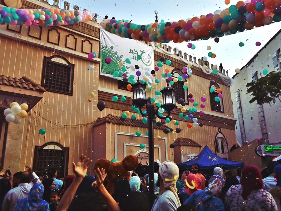 Glitter and balloons fill the air during a celebration of ʿId al-Fitr.