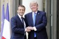 A different handshake:  French President Emmanuel Macron welcomes US President Donald Trump at the Elysee Presidential ...