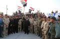 Iraq's Prime Minister Haider al-Abadi raises the national flag as he addresses forces in Mosul's Old City on Monday.