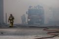 Firefighters work in thick smoke at a fire in a recycling plant in Coolaroo.