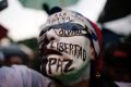 A woman with her face painted with Spanish words "Freedom, peace, don't forget" attends a vigil to honour the more than ...