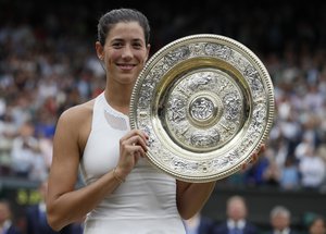 Spain’s Garbine Muguruza holds the trophy after defeating Venus Williams of the United States in the Women's Singles final match on day twelve at the Wimbledon Tennis Championships in London Saturday, July 15, 2017.