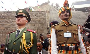 A Chinese soldier, left, and an Indian soldier maintain ceremonial positions marking the international boundary of their countries respectively at the opening of the Nathu La Pass, in northeastern Indian state of Sikkim, Thursday, July 6, 2006.