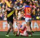 Brisbane's Nick Robertson hits the ground after an incident involving Tiger Dustin Martin as Jarrod Berry comes in to ...