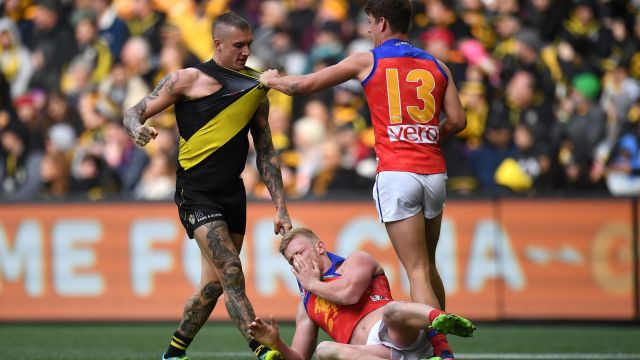 Brisbane's Nick Robertson hits the ground after an incident involving Tiger Dustin Martin as Jarrod Berry comes in to ...